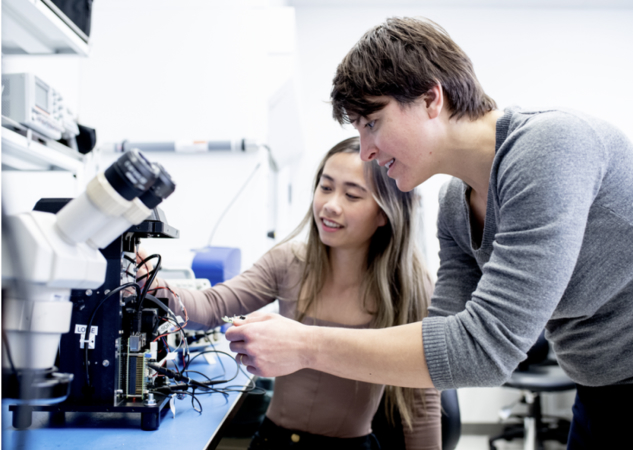 Two researchers building the Remoscope, a malaria diagnostic tool