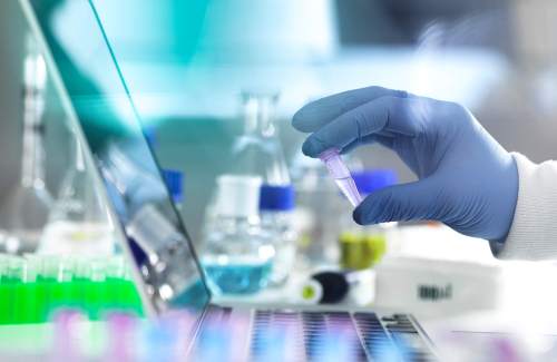 Photo of a scientist examining a vial.