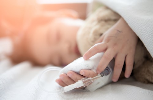 stock photo baby girl sick in hospital, saline solution intravenously.