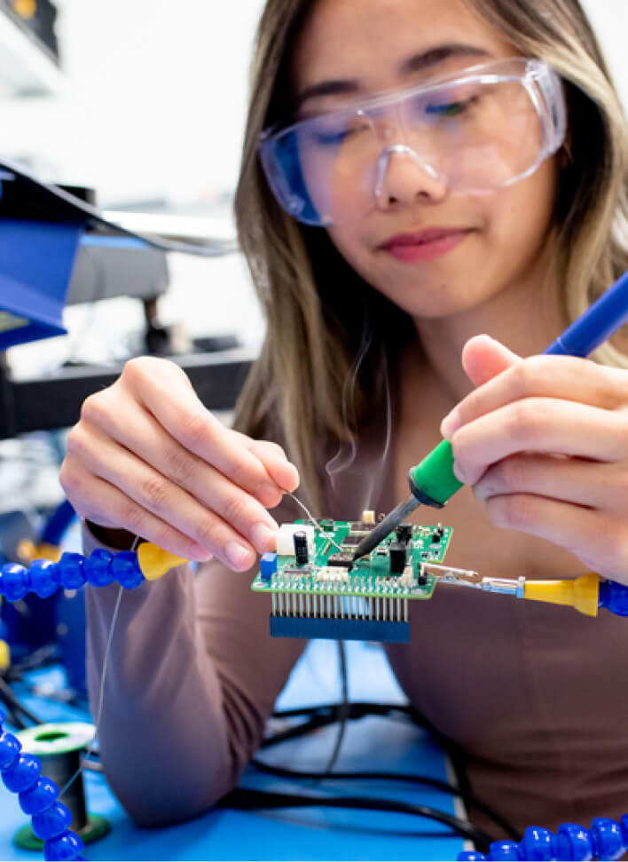 Science researcher wearing safety glasses focused on her lab work at CZ Biohub Network