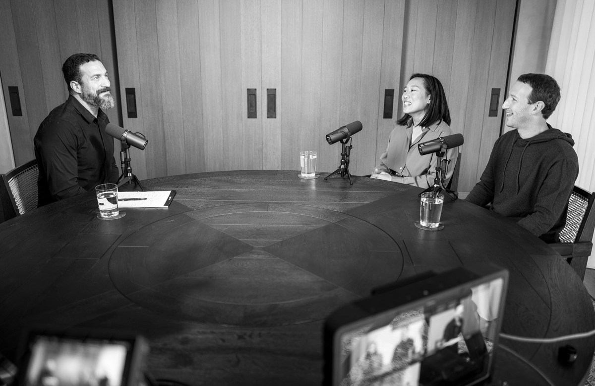 Andrew Huberman sits across a table from Priscilla Chan and Mark Zuckerberg. All three speak to each other and into microphones.
