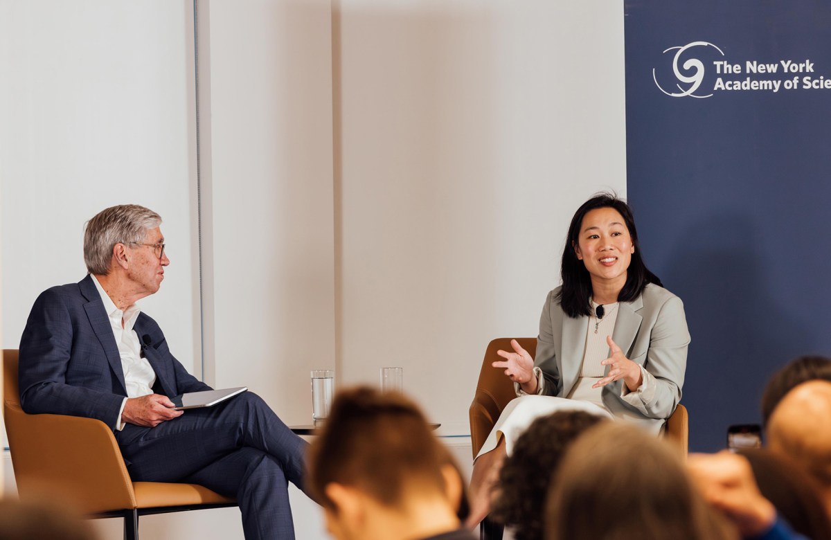 Drs. Richard Lifton and Priscilla Chan sit side-by-side in armchairs on stage.